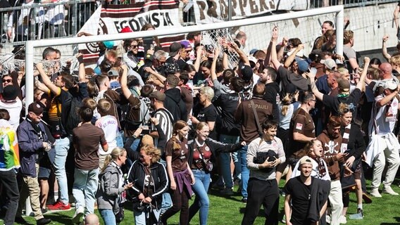 Fans des FC St. Pauli demontieren nach dem Schlusspfiff die Tornetze, um sich ein Erinnerungsstück des Aufstiegs 2024 zu sichern. © IMAGO / osnapix 