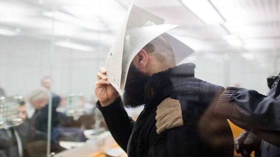 Ahmad Abdulaziz Abdulla A. hält einen Zettel vor sein Gesicht © picture alliance Foto: Julian Stratenschulte